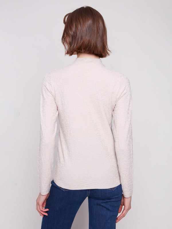 Elegant slim-fit oat sweater paired seamlessly with blue denim and ankle boots for a refined look by Charlie B.