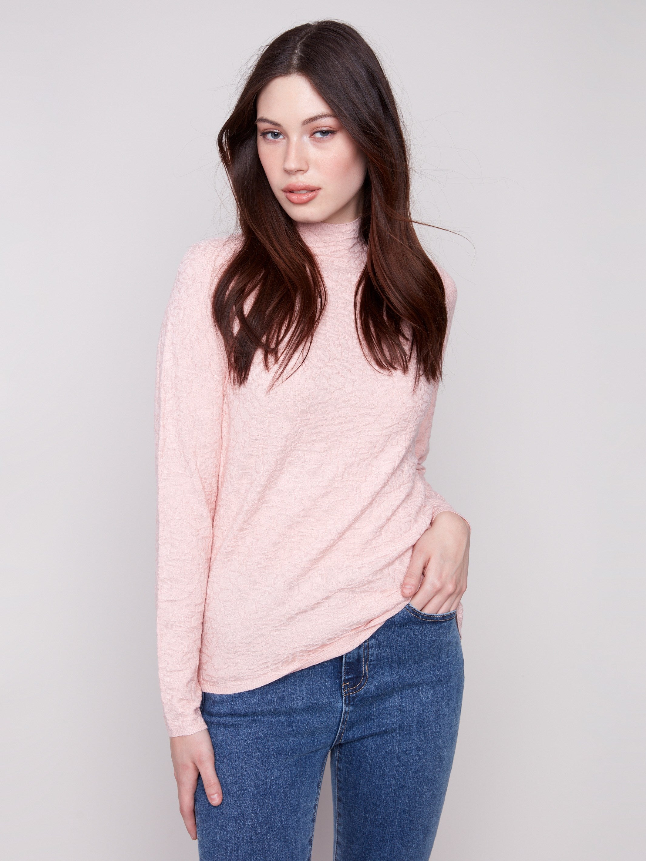 Ballet pink sweater with a mock neck and slim fit, paired perfectly with blue jeans for a chic look by Charlie B.