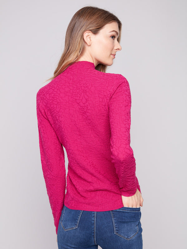 Slim-fit hibiscus sweater in textured fabric, matched with stylish blue jeans by Charlie B.