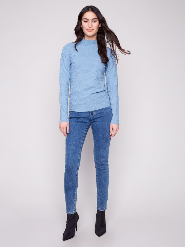 Textured long-sleeve sweater in oxford blue, styled elegantly with denim jeans by Charlie B.