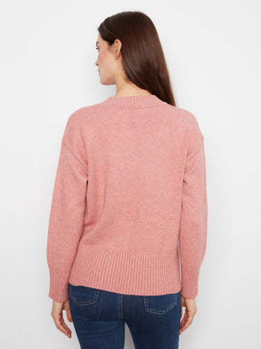 Chic pink sweater designed with comfort in mind, showcasing ribbed cuffs and hem for an added touch of sophistication. By Charlie B.