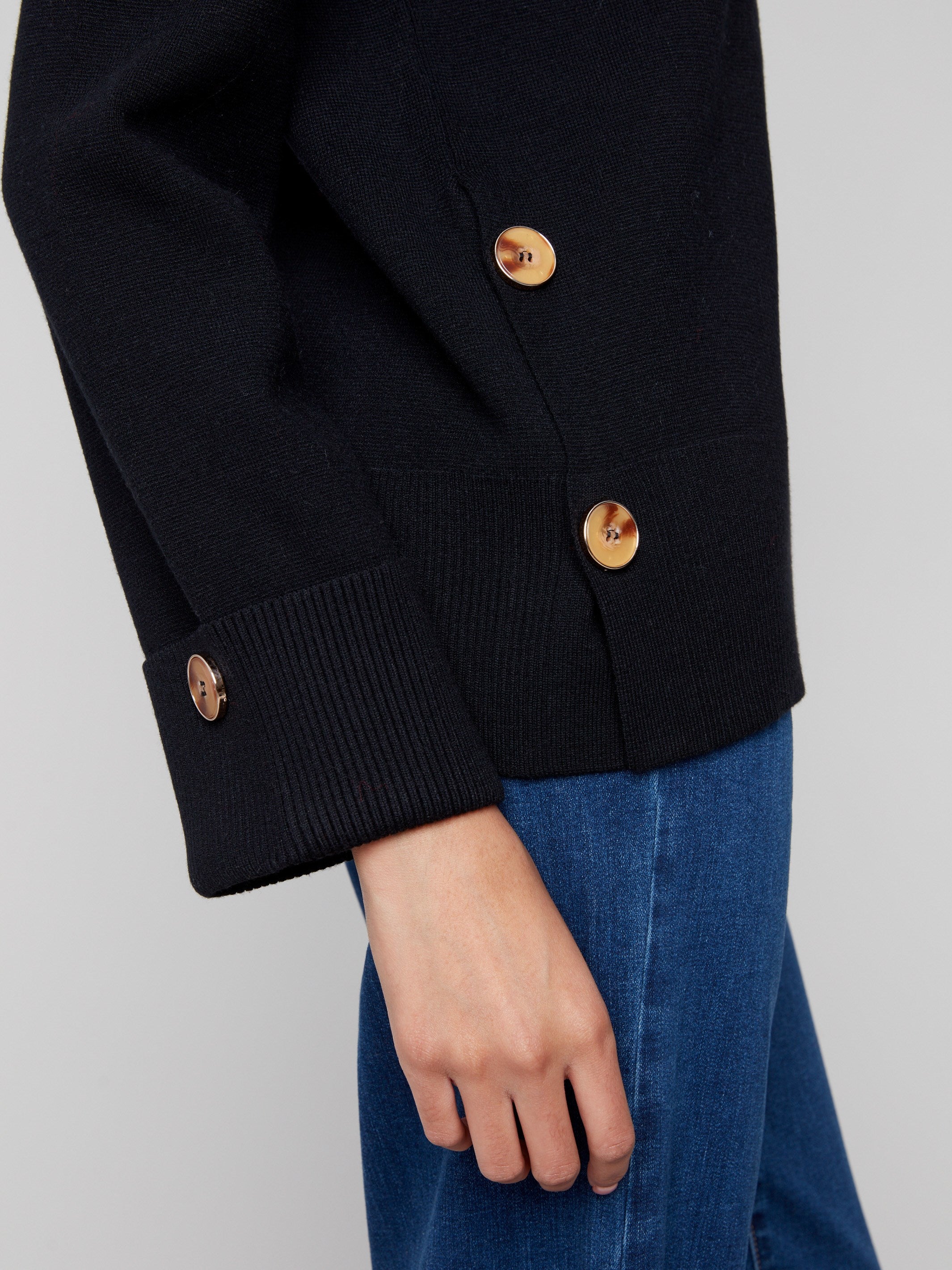 Black sweater showcasing wide cuffs and side buttons, creating a refined look for versatile styling options by Charlie B.