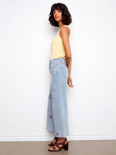 Regular rise stretch denim pants adorned with colorful pixelated flowers for a unique fashion statement. By Charlie B.