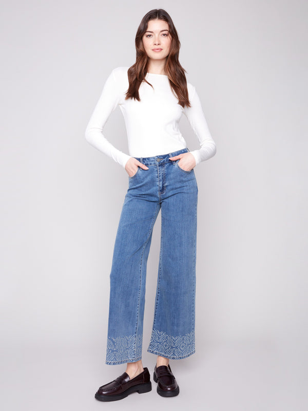 Medium blue jeans featuring a wide leg and five-pocket design, crafted in stretch denim material by Charlie B.