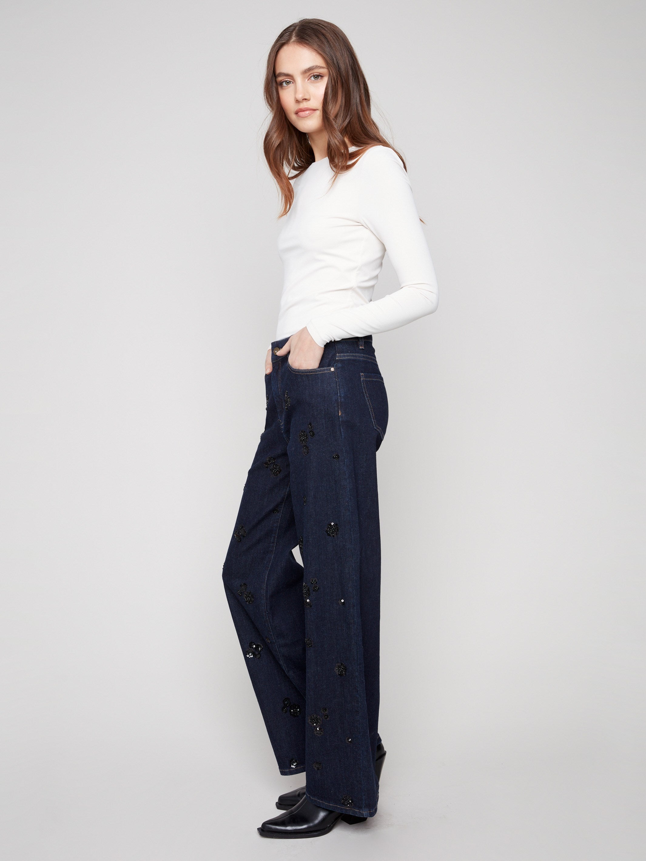 Wide-leg silhouette in rich blue denim with intricate sequin floral patterns for an elevated style by Charlie B.