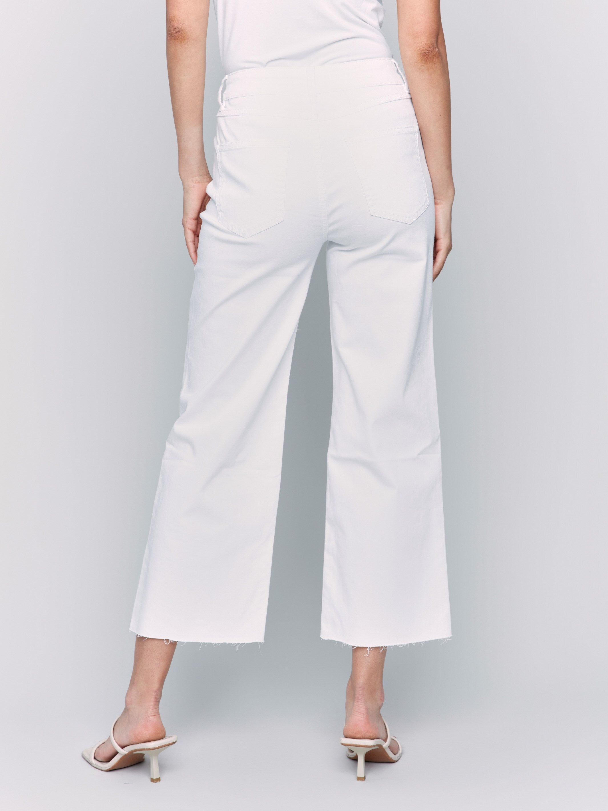 White wide-leg twill pants with raw edge hem, five-pocket design, and regular rise by Charlie B.