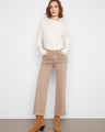 Latte wide leg pants feature a five-pocket design, paired with a white top and brown boots for a chic look by Charlie B.