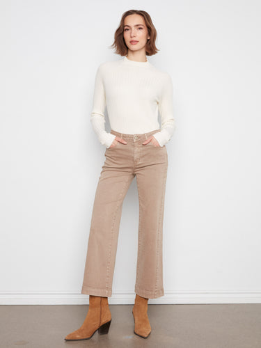 Latte wide leg pants feature a five-pocket design, paired with a white top and brown boots for a chic look by Charlie B.
